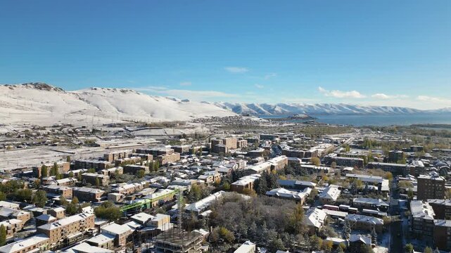 Aerial panoramic panning view Sevan town and Lake Sevan. Famous Sevan lake - large, high-altitude lake in eastern Armenia. Winter travel visit destination Armenia concept.