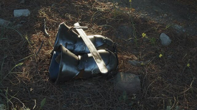 A copy of a medieval sword lies on metal protective mittens. Reconstruction of historical events