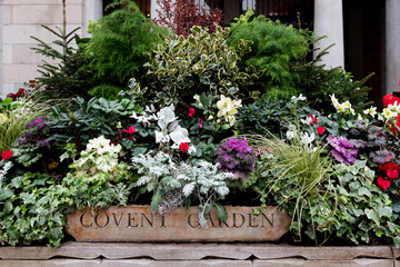 Floral display marking an entrance to Covent Garden, an elegant shopping and entertainment hub in London's West End.
