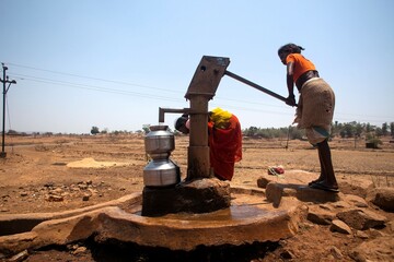 Tribal woman pumping water from hand pump, India, Asia