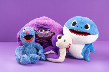 Different soft toys on a purple background the concept of friendship between different
