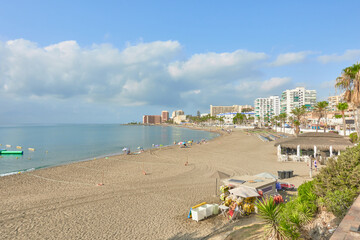 View of Bil Bil Beach in Benalmadena Costa, Malaga (Andalusia, Spain), with golden sand, cityscape and the horizon on the Mediterranean Sea