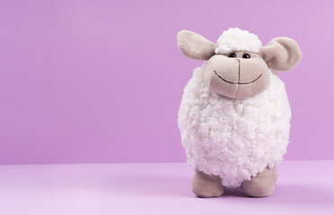 Soft toy sheep on a purple background with space for your text.