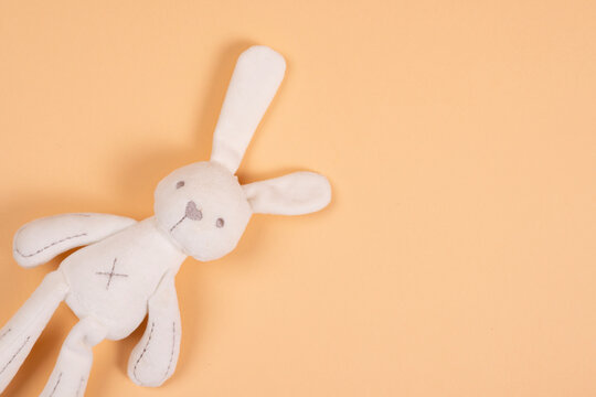 Soft toy white hare handmade on beige background.