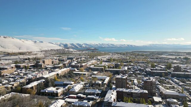 Aerial fly over view Sevan town and Lake Sevan. Famous Sevan lake - large, high-altitude lake in eastern Armenia. Winter travel visit destination Armenia concept.