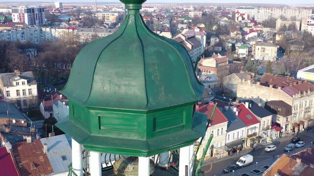 A quadcopter captures a stunning panorama of Drohobych, Ukraine, focusing on the central square where a historic town hall stands proudly. The video highlights the town's charm and rich heritage from