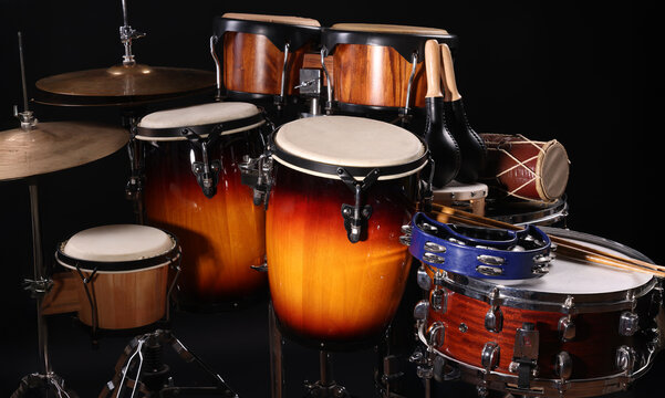 Different drums on a black background, percussion musical instruments