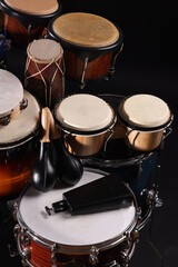 Different drums on a black background, percussion musical instruments