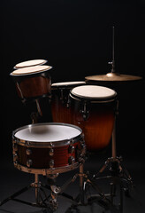 Different drums on a black background, percussion musical instruments