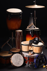 Different drums on a black background, percussion musical instruments