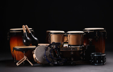 Different drums on a black background, percussion musical instruments
