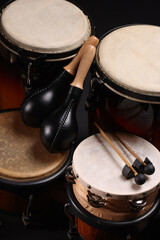 Different drums on a black background, percussion musical instruments