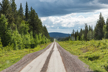 the view of a gravel road in the wilderness of norway