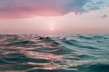Obraz premium The tranquil ocean waves gently ripple under a mesmerizing pastel sunset, painting the sky with shades of pink and blue.