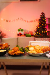The cozy Christmas party setup features variety of beautifully wrapped gift boxes on table, alongside festive food dishes fried chicken, grilled chicken, salad, popcorn, and bread in living room.