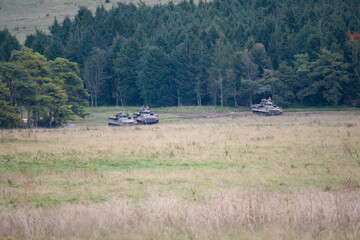 Fototapeta premium a group of a British army Warrior FV510 light infantry fighting vehicle tanks in action on a military exercise, Wiltshire UK
