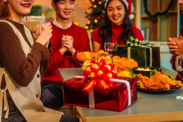 An upbeat New Year’s Eve celebration with Asian friends, family, colleagues, blending work and holiday vibes.while table brims with champagne, wine, gift boxes, delicious foods grilled chicken