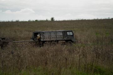British army bae systems, Puch, Daimler, Pinzgauer High-Mobility All-Terrain 6x6 vehicle towing a 105mm Light Artillery Gun on a military exercise © Martin