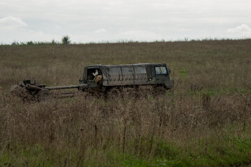 British army bae systems, Puch, Daimler, Pinzgauer High-Mobility All-Terrain 6x6 vehicle towing a 105mm Light Artillery Gun on a military exercise © Martin