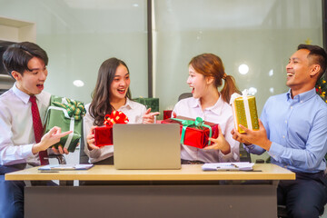 Festive office Christmas party with friends and colleagues celebrating after work. Asian business people wear Santa hats, enjoy grilled chicken, drinks, and gifts,  indoor scene with holiday lights.