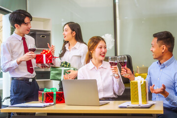Festive office Christmas party with friends and colleagues celebrating after work. Asian business people wear Santa hats, enjoy grilled chicken, drinks, and gifts,  indoor scene with holiday lights.