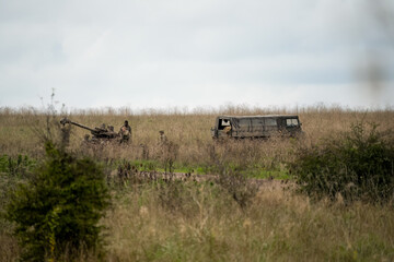 soldiers working on a 105mm Light Artillery Gun attavhed to a Pinzgauer 6x6 utility vehicle on a military exercise  © Martin