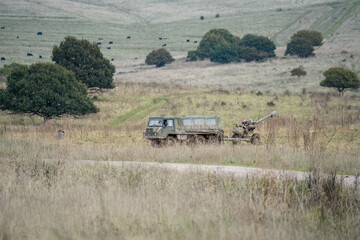 British army bae systems, Puch, Daimler, Pinzgauer High-Mobility All-Terrain 6x6 vehicle towing a 105mm Light Artillery Gun on a military exercise