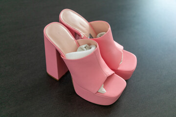 High heels with block heel and platform 90s mules in pink on an anthracite table