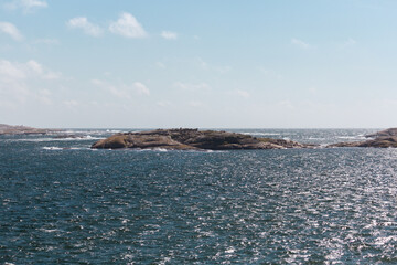 scissor islands off sm&ouml;gen in sweden, with bright sunshine and small white clouds
