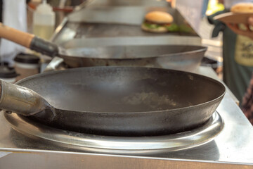 Metal frying pans ready for use in a small street cafe. Close-up