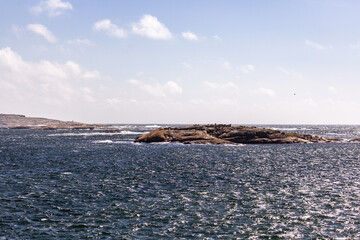 scissor islands off sm&ouml;gen in sweden, with bright sunshine and small white clouds