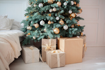 Decorated Christmas tree with gifts arranged below in cozy bedroom setting