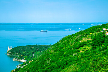 A majestic castle is perched on a hill, overlooking a serene body of water