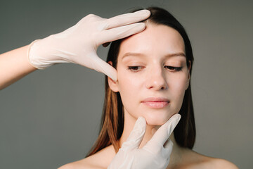 Fototapeta premium Face building. Contour plastic for correcting the shape of the face. Markup skin for beauty treatment. Doctor prepares women's skin for beautiful face contour