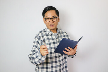 Portrait young man wear glasses casual shirt holding the books happy smile point finger at you isolated.