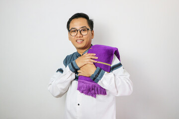 Moslem Asian man looking to the camera with happy face expression while waving his hand to greet others