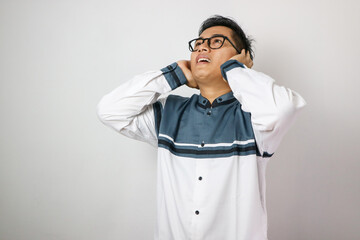 Fototapeta premium Young asian muslim man wearing moslem clothes and prayer mats in his shoulder. He is on the call to prayer or adzan