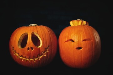 Two funny Halloween Pumpkins on dark background.