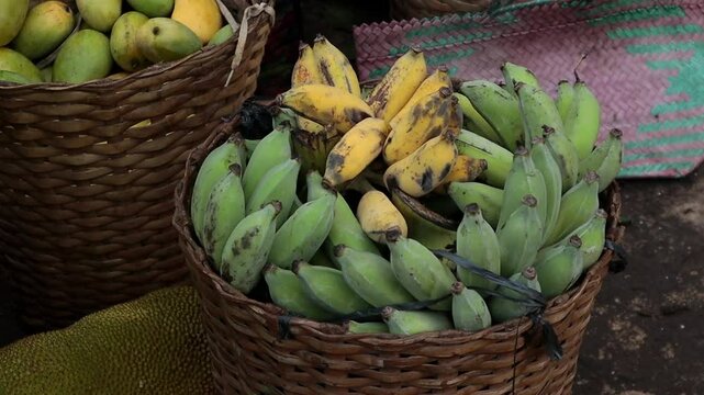 a wooden basket filled with green and yellow bananas, a traditional fruit
