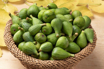 Basket with fresh picked green unripe figs close up 