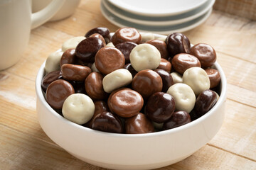 Bowl with a mix of chocolate covered traditional Dutch kruidnoten, gingerbread cookies, close up 