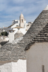 Narrow street in ancient southern Italian town with traditional trulli dwellings, Alberobello, Italy