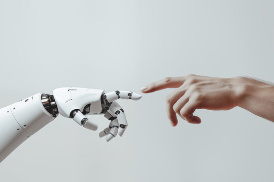 A white cyborg robotic hand with an extended finger pointing toward a human hand with an extended finger. AI robot finger and human finger making contact, isolated on a gray background.