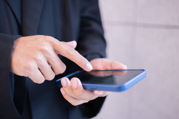 He using mobile phone in communication.Close-up A businessman working on his smartphone