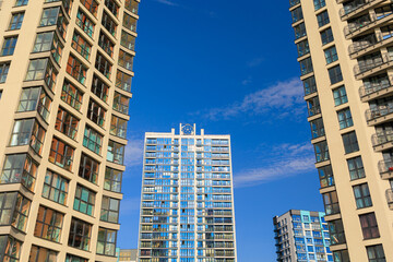 Obraz premium City view, modern buildings and skyscrapers against the blue sky.