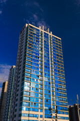 Obraz premium Modern buildings, walls and windows. City view on a sunny day. 