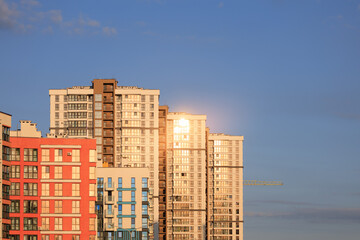 Modern buildings, walls and windows, reflections and sun rays. City view on a sunny day. 