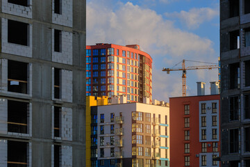 Construction cranes and new buildings, construction work of modern skyscrapers on a sunny day.