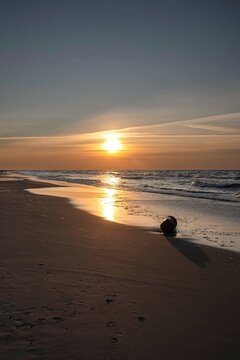 Sandy beach with the sun in the background. Beautiful sunset over the Baltic Sea in Gdynia, Poland.