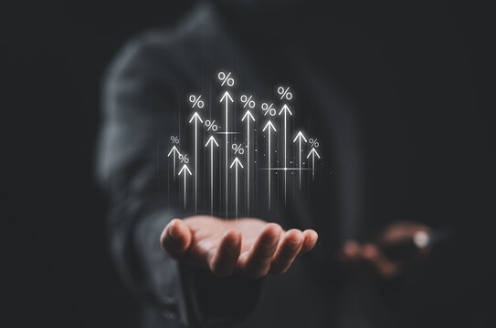 Businesswoman showing percentage icons and up arrow icons with graph indicators. Concept of financial interest rates and mortgage rates. Interest Rates Stocks Finance Ratings Mortgage Rates.